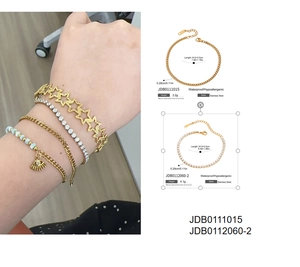 Detailansicht der goldfarbenen Edelstahl-Armbänder mit Stern-, Tennis- und Evil-Eye-Charms