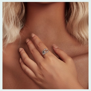 Macro shot of retro silver crab ring featuring a grey gemstone on model's finger