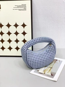 Detail of the light purple woven leather texture and elegant gold zipper on a crescent bag
