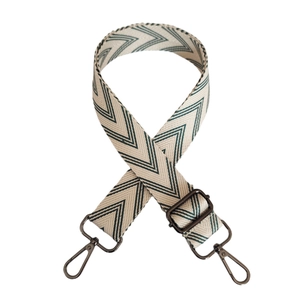 Detail of adjustable cream and green herringbone woven canvas strap with dark metal clips