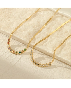 Detailed view of 18K gold snake chains featuring colorful and white zirconia stones