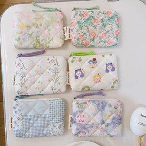Flat lay of quilted floral cotton pouches with various colorful patterns and zippers