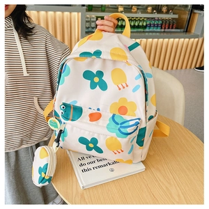 Detail of cute floral print kids backpack in beige with matching small coin purse charm