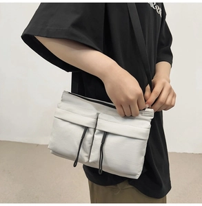 Nylon messenger bag in beige featuring dual front pockets with black drawstring toggles