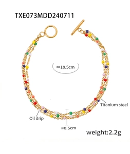 Detail of triple-layer gold titanium steel bracelet with colorful enamel beads and toggle clasp
