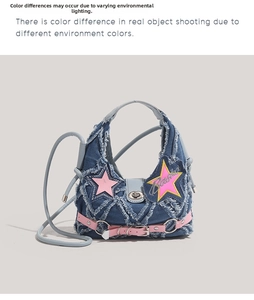 Detail of denim crossbody bag featuring pink star patches and distressed raw edges