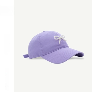 Detail of light purple cotton baseball cap with bead-embellished bow and soft top design