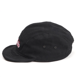 Detail of black 5-panel camping cap with red embroidered box logo and metal eyelets