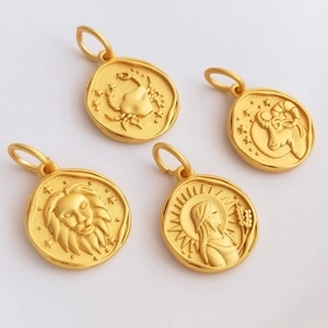 Detailed closeup of ancient style gold zodiac coin pendants, featuring intricate constellation relief.