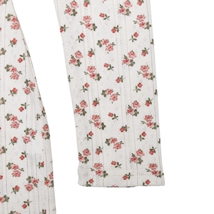 Gros plan sur un tricot à fleurs roses avec des textures ajourées verticales délicates