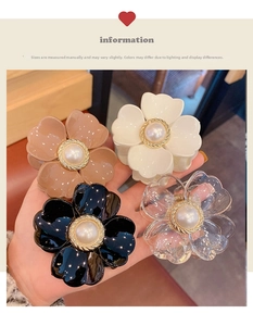 Detailed view of four floral hair claws with pearls in coffee, white, black, and clear colors