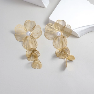 Elegant gold wire flower drop earrings with white pearls in a minimalist luxury style
