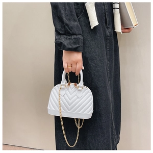 Detail of white jelly shell bag featuring V-quilted texture and elegant gold chain strap