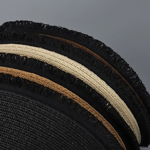 Macro detail of sun hat brim featuring layered black fringe and beige woven textures