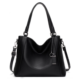 Detail of black pebbled leather tote bag with metallic hardware and adjustable strap