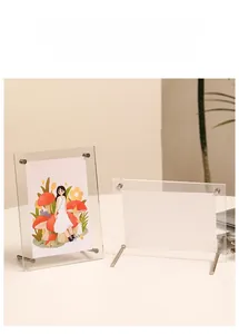 Close-up of clear acrylic picture frame showing metal support screws and dual orientation