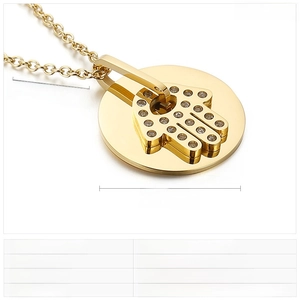 Macro shot of gold Hamsa pendant with sparkling rhinestones on stainless steel chain