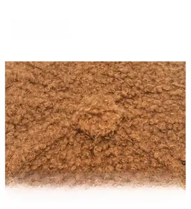 Detail shot of the plush curly lamb wool texture and fine stitching on a brown baseball cap