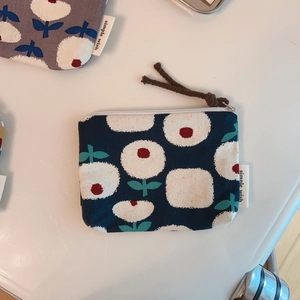 Detailed shot of floral canvas coin purses in navy and gray with simple wish label
