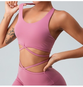 Detail of cross-waist yoga set with racerback sports bra and breathable pink fabric