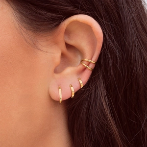 Detailed close-up of golden floral stud earrings and double layer ear cuff set