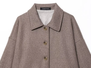 Detailed close-up of brown wool-like texture and lapel collar of a short coat