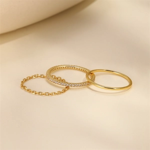 Detailed view of three minimalist gold stackable rings with one featuring fine zircons