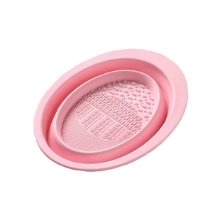 Pink foldable silicone cleaning bowl with textured interior for makeup brushes