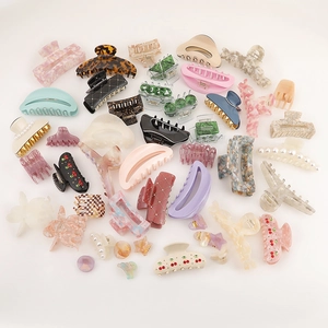 Various acetate bow hair claws in marble and solid colors on a clean white background