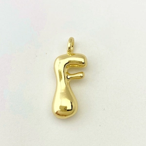 Detailed close-up of polished golden letter F balloon pendant with high gloss finish