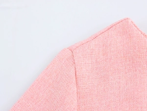 Close-up of pink tweed fabric texture and shoulder detail on a sweet style dress