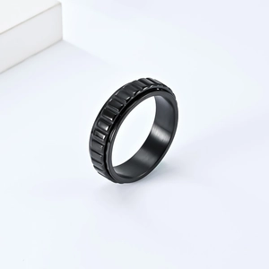 Détail macro d'une bague noire en acier inoxydable avec texture industrielle d'engrenage