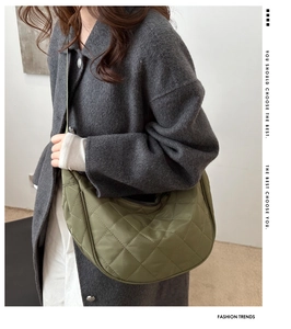 Quilted green crescent crossbody bag styled with a grey wool coat for fashion trends