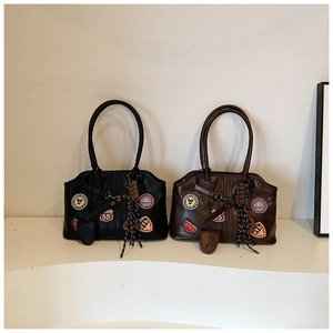 Detailansicht der Vintage-Tragetaschen mit bunten Stickereien und Quastenanhängern
