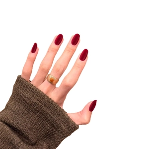 Vintage gold statement ring with sunburst design and red oval gemstone on hand