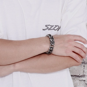 Detail shot of vintage silver dragon bone chain bracelet in punk style on male wrist