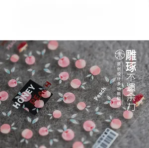 Macro detail of ultra-thin peach nail art stickers with Honey Peach lettering and motifs