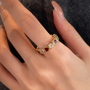 Gold-plated open ring with red enamel and white zircon hearts worn by a model