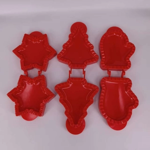 Detailed view of red 3D Christmas tree and snowflake plastic cookie molds in open state