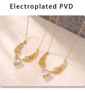 Macro view of gold heart zircon angel wings necklace on beige textured rock surface