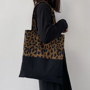 Detail of leopard print canvas tote bag featuring reinforced black base and large capacity
