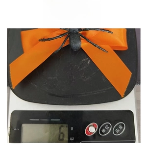 Gros plan d'une pince à cheveux araignée d'Halloween avec un nœud orange pesant six grammes