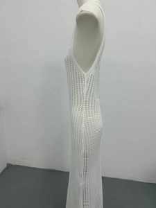 Side view of white crochet maxi dress with intricate hollow-out patterns and side slit