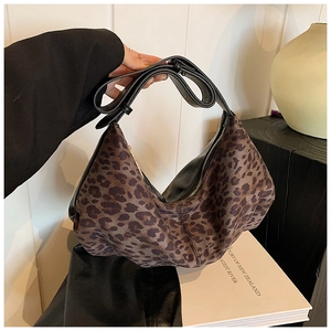 Detail of leopard print crescent bag with black leather strap and suede texture finish