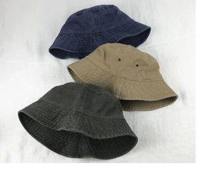 Detailed flat lay of washed cotton bucket hats in navy, khaki and charcoal grey tones
