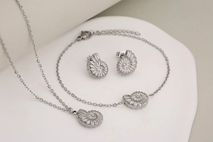 Détail du parure de bijoux coquillage argenté avec collier, bracelet et boucles d'oreilles