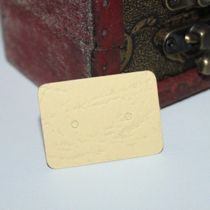 Close-up of small beige kraft paper earring display card with dual pre-punched holes