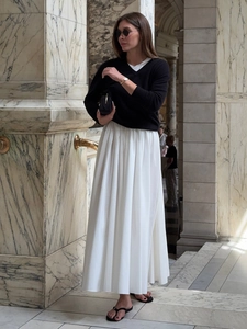 Detail of white pleated maxi skirt with premium draped fabric and elastic waist design