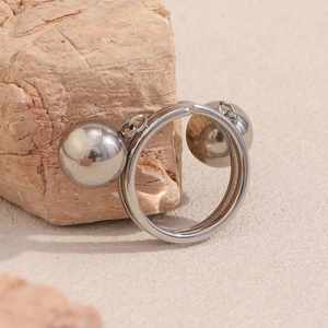 Detail of silver polished double ball ring resting on a textured natural rock