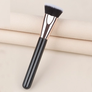 Detail of angled dual-tone synthetic bristles and rose gold ferrule on makeup brush